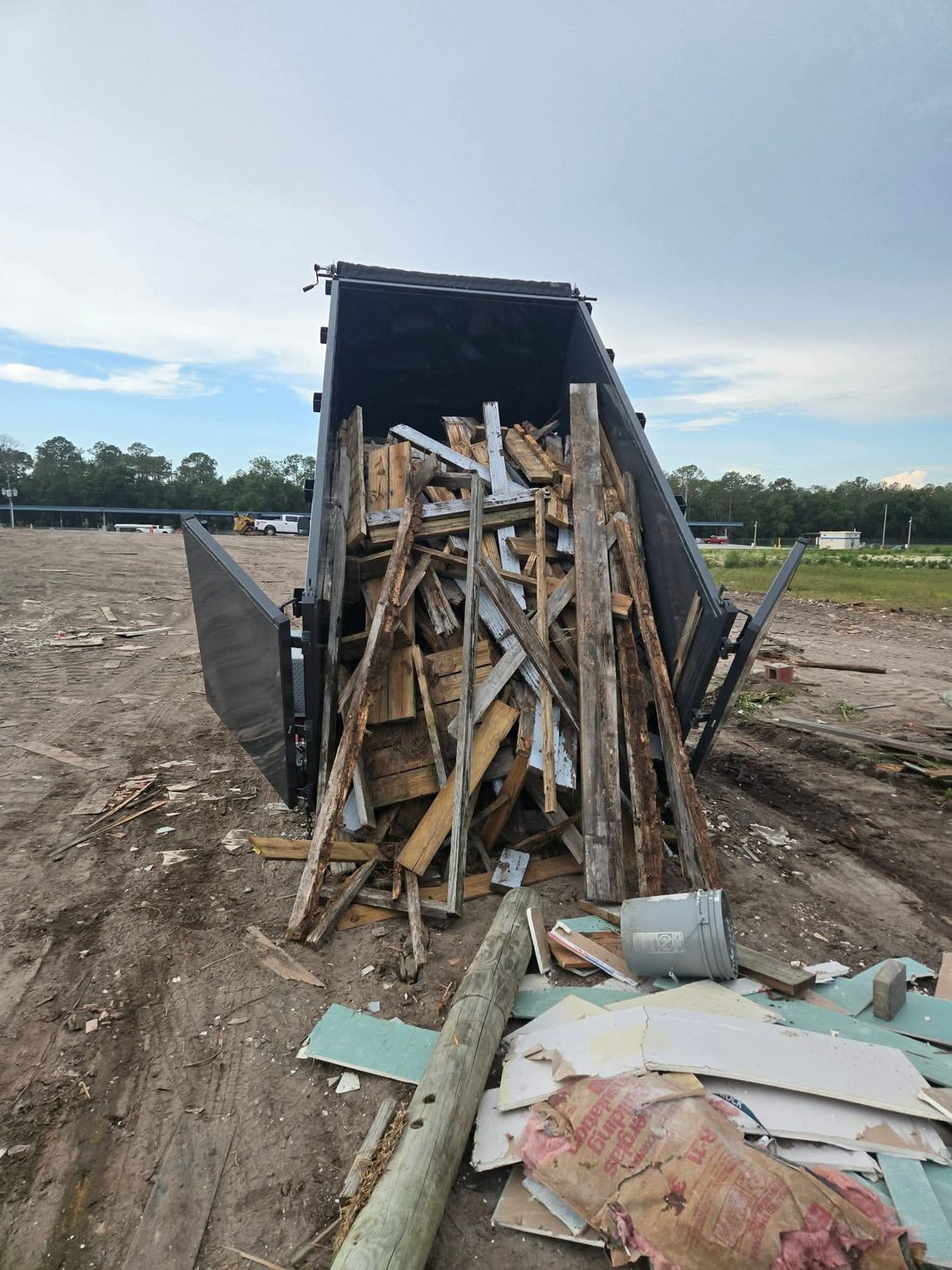 Lance & Load dump trailer unloading construction and wood debris at a cleanup job site in Florida